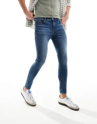 ASOS DESIGN spray on jeans with power-stretch in mid wash blue