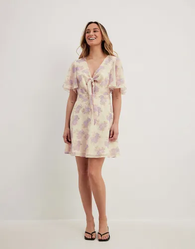 NA-KD tie front chiffon mini dress with floral print in beige-Neutral