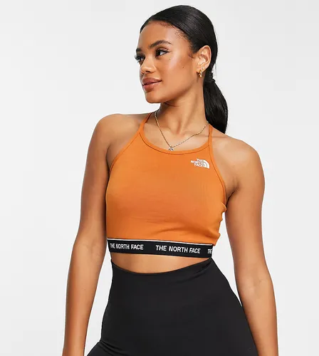 The North Face strap back crop top with logo hem in orange Exclusive at ASOS-Brown